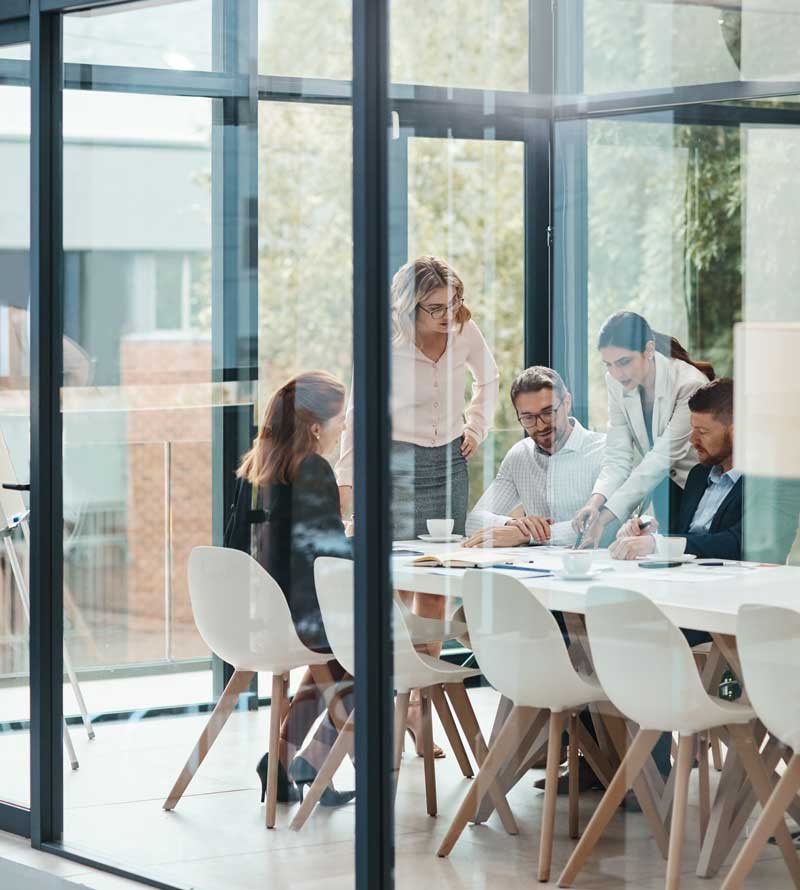 business professionals inside conference room with glass walls
